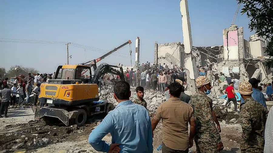 Rescue workers and residents search through the rubble in the aftermath of an Israeli-U.S. strike on a girls' elementary school in Minab, Iran, on Saturday. [ AP ]
